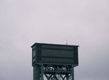 Low angle view of communications tower against sky