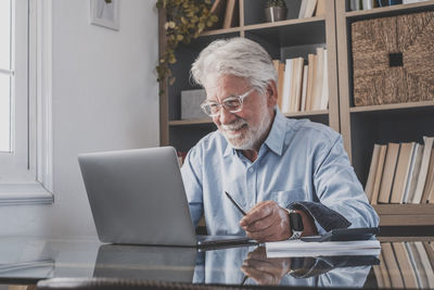 Smiling senior businessman working at office