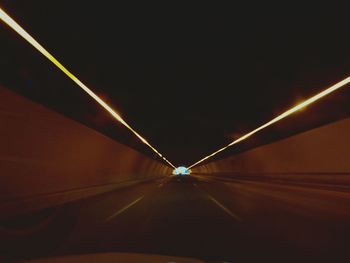 Illuminated tunnel at night