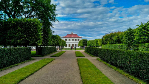 Footpath in garden against sky