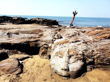 Scenic view of rocks on beach against sky