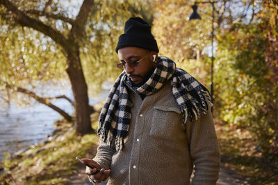 Man using phone in autumn park