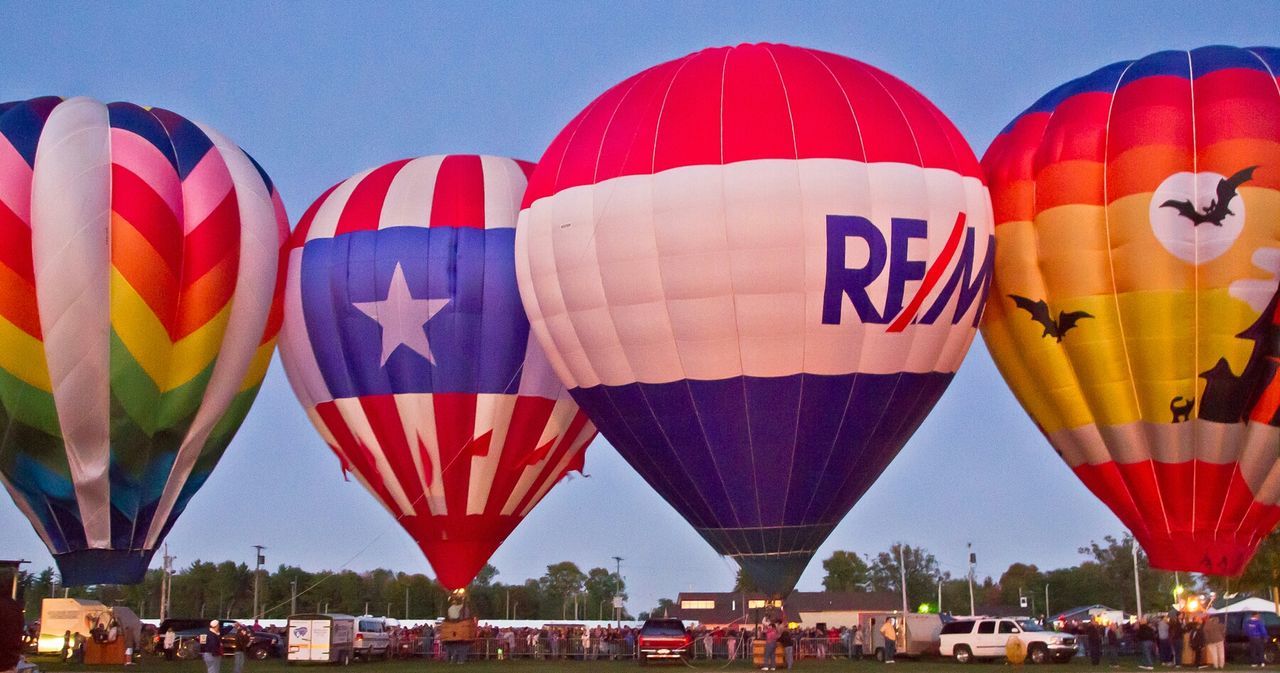 multi colored, flag, hot air balloon, patriotism, national flag, celebration, decoration, sky, hanging, clear sky, in a row, balloon, variation, cultures, red, incidental people, low angle view, identity, large group of people, outdoors