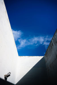 Low angle view of white wall against blue sky