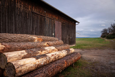 Barn on field by building against sky