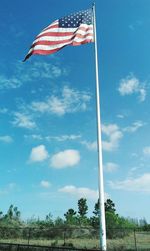 Low angle view of flag against blue sky