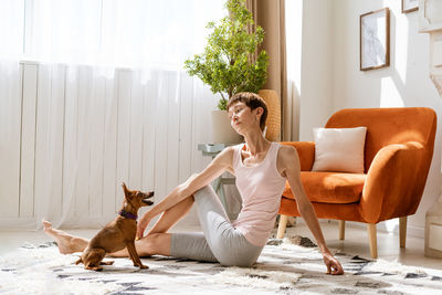 Concept healthy lifestyle. yoga and fitness. cute woman with small dog