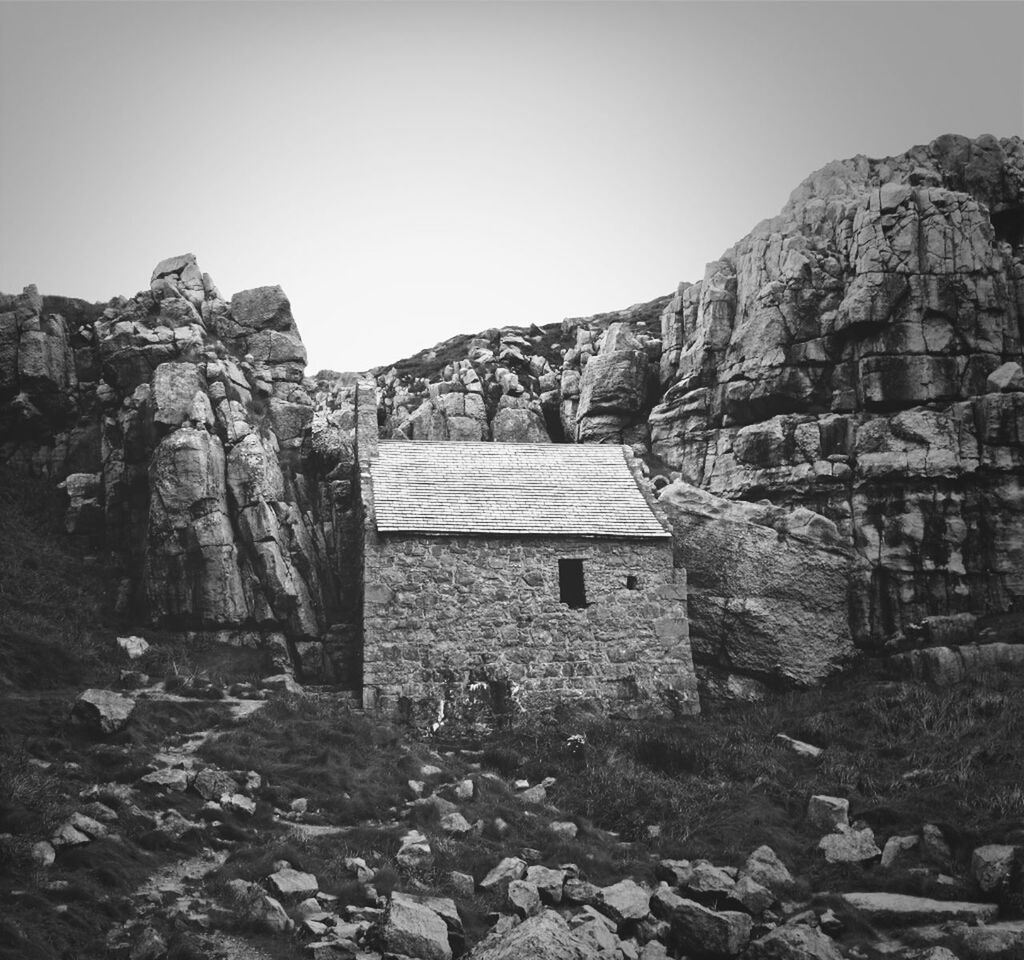 built structure, architecture, clear sky, building exterior, rock - object, stone wall, rock formation, house, rock, mountain, old ruin, old, copy space, stone, history, day, abandoned, no people, outdoors, stone - object