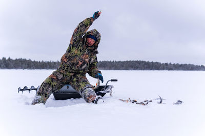 Full length of woman on snow covered shore against sky