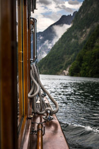 Close-up of boat on river against mountain