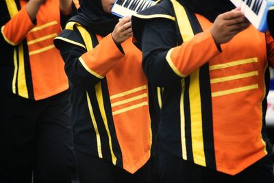 Midsection of musicians wearing uniform