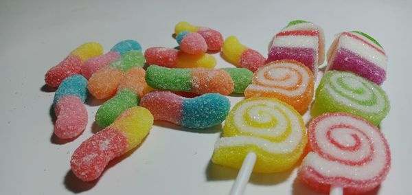High angle view of multi colored candies against white background
