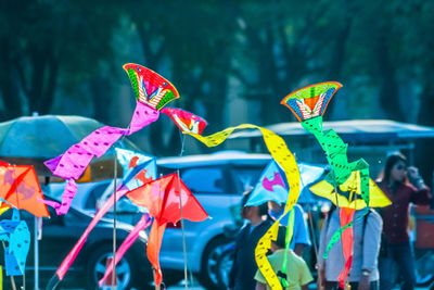 Multi colored kites against traffic in city