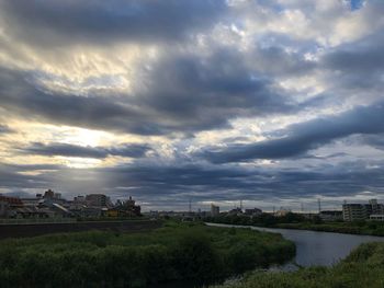 Scenic view of river by buildings against sky