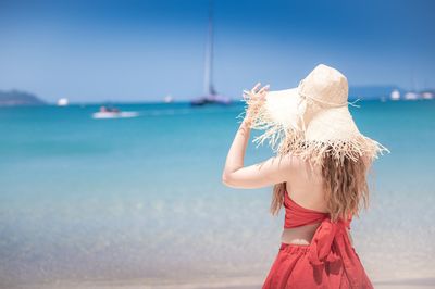 Full length of woman wearing hat against sea