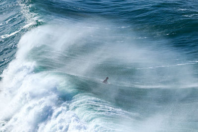 Surfer crossing a big wave