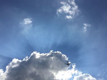 Low angle view of airplane against blue sky