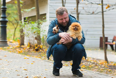 Mature man playing with puppies at park