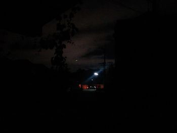 Silhouette car against illuminated sky at night