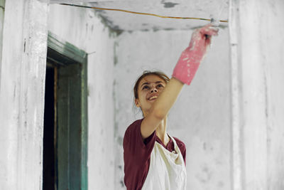 Portrait of woman standing against wall