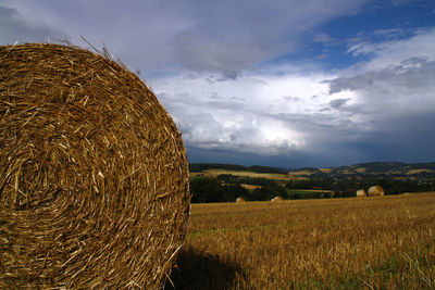 Hay bales on field against sky