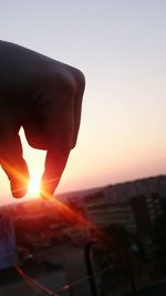 Close-up of silhouette man against cityscape during sunset