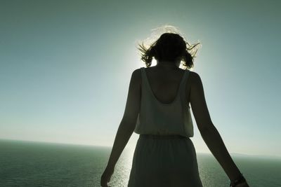 Rear view of woman standing against clear sky