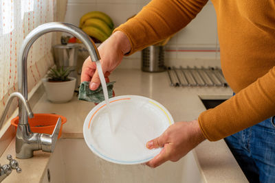 Midsection of woman holding kitchen at home