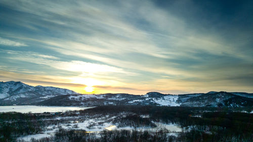 Scenic view of snowcapped mountains against sky during sunset