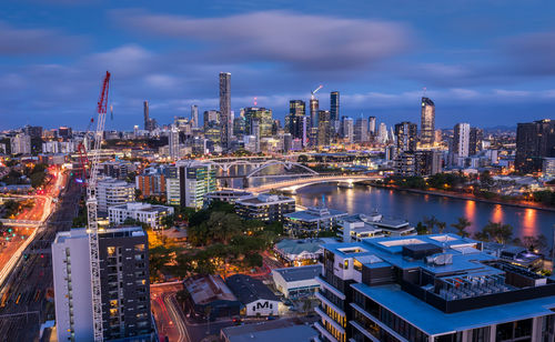 Illuminated buildings in city against sky