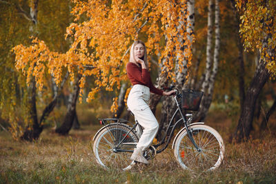 Young woman riding bicycle in autumn