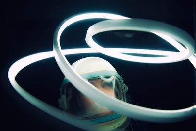 Senior woman wearing space suit with illuminated lighting equipment in dark