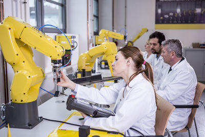 Engineers examining industrial robots