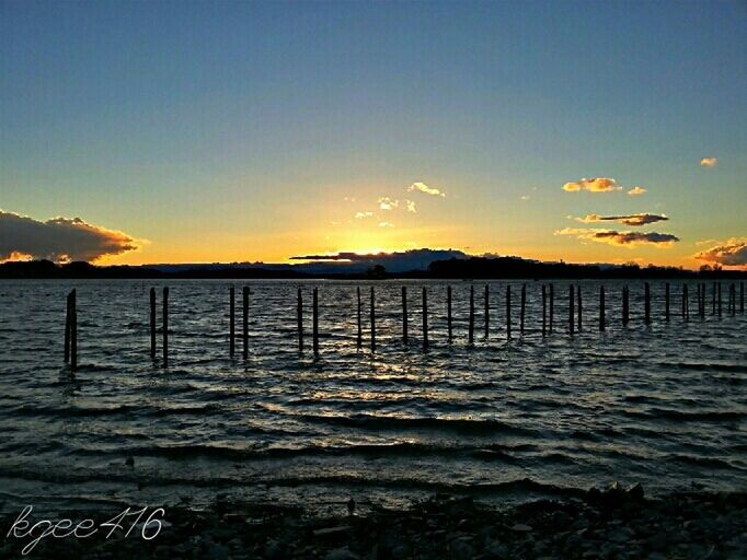 water, tranquil scene, sea, sunset, scenics, tranquility, beauty in nature, pier, nature, idyllic, sky, horizon over water, wooden post, clear sky, beach, copy space, blue, calm, silhouette, reflection