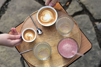 Cropped hand of man holding coffee on table