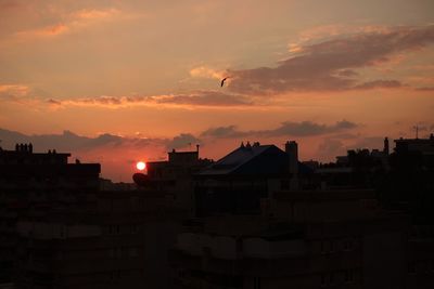 Silhouette cityscape against sky during sunset