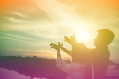 Rear view of silhouette man standing against sky during sunset