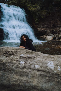 Portrait of young woman in waterfall