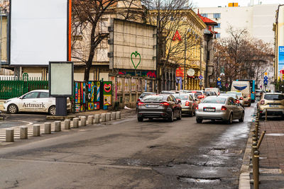 Cars on road by buildings in city