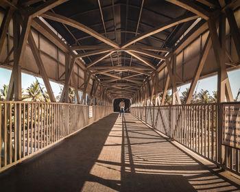 Rear view of woman walking on footbridge