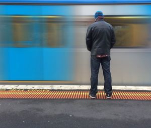 Rear view of man standing in front of wall