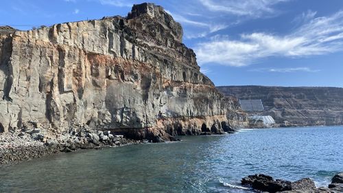 Rock formations by sea against sky