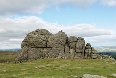 Rock formation on field against sky