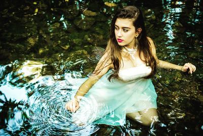 Portrait of beautiful young woman against trees