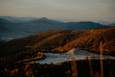 Scenic view of lake and mountains against sky during sunset