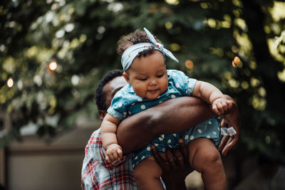 Cute boy holding baby girl outdoors