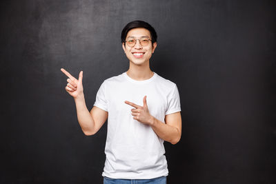 Man pointing against black background