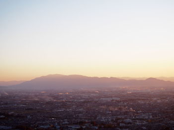 Aerial view of city against clear sky during sunset