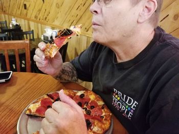 Close-up of man eating food on table