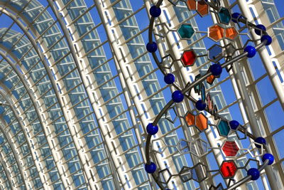 Low angle view of multi colored umbrellas on city against sky